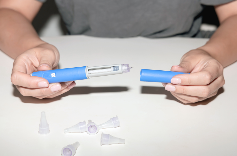 Close-up of a woman's hands holding a semaglutide pen.